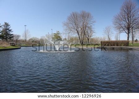 A picture of a quiet nature scene in park, with water fountain