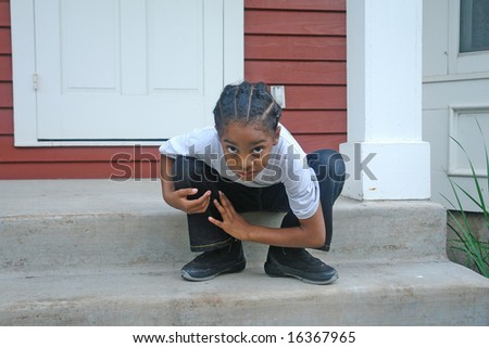 A picture of a humorous little boy sitting on  porch