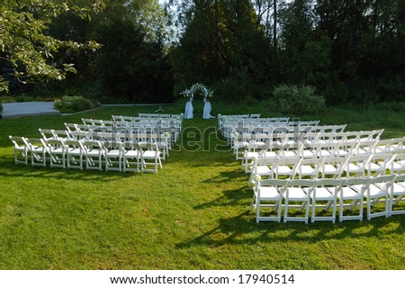 stock photo Outdoor wedding reception venue set up with white chair