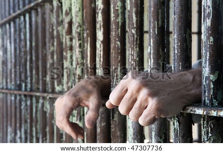 Prisoner Hands Leaning on His Cell