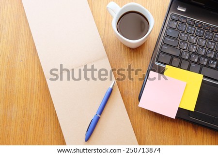 note book and black coffee on wooden table with post it