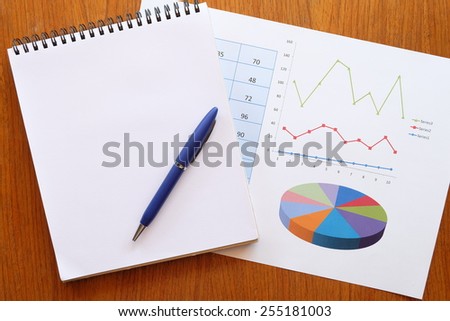 note book and chart on the wooden table