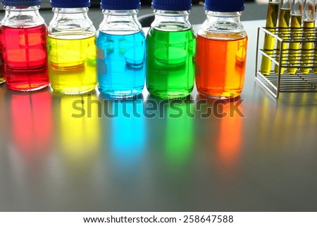 Colorful fluid in bottle and test tube for laboratory use on table laboratory
