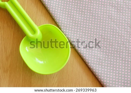 plastic spoon on dot cloth with wooden background