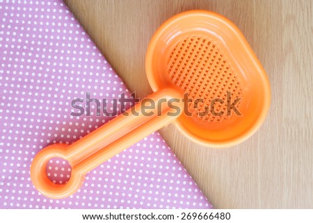 plastic spoon on wooden and dot cloth background