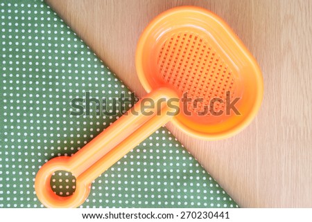 plastic spoon on wooden and dot cloth background