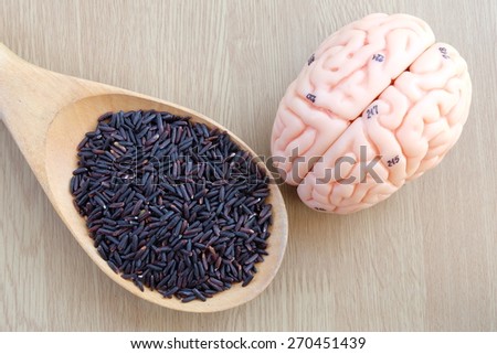 brain and purple rice on wooden background with eat clean concept