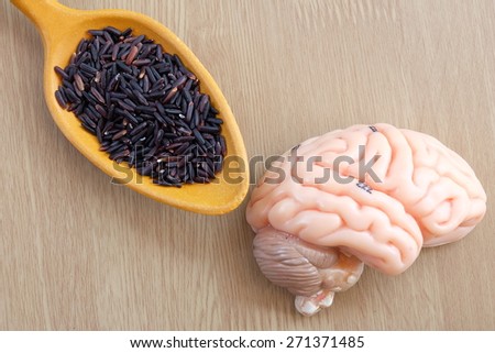 brain and purple rice on wooden background with healthy concept