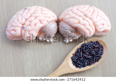 brain and purple rice on wooden background with healthy concept