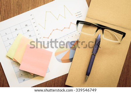 chart and note book on the wooden table with vintage color style