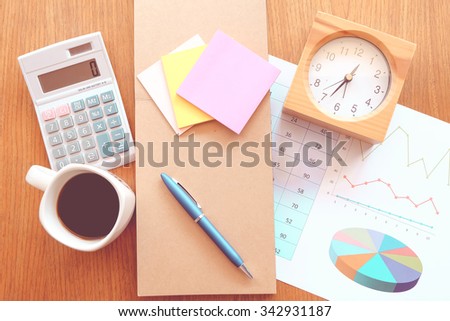 calculator and chart on the wooden table with vintage color style