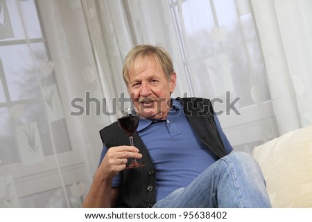 senior citizen drinking a glass of red wine