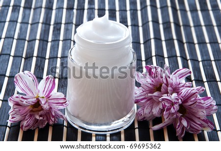 Cream for face and flower on a bamboo
