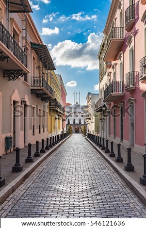 Cobblestone street of old town leading to historic building La Fortaleza at the end of the street