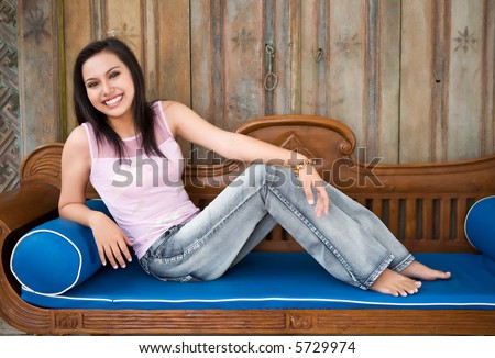 Asian Indonesian model reclining on love seat