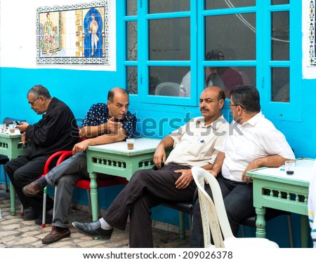 SOUSSE, TUNISIA - CIRCA NOVEMBER 2013 - Tunisian men chat outside medina cafe