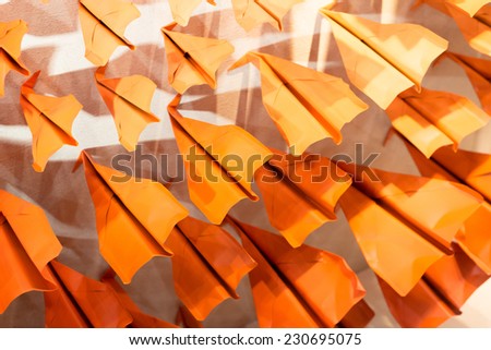 Lots of Paper Aeroplances pushing against wall