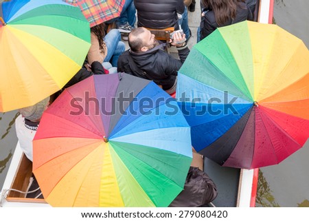 GHENT, BELGIUM - CIRCA APRIL 2015 : Tourists in Boat on Canal with Rainbow Umbrellas