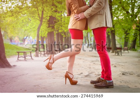 Young fashion elegant stylish couple  feet , in love , stand opposite each other on park in spring sunny weather