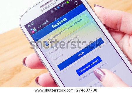 LVIV, UKRAINE - May 03, 2015: Hand holding white Samsung Smart Phone with Facebook Social Network Log In Screen