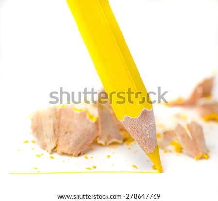 Sharpened yellow pencil draws a line on a white paper