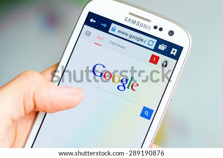 LVIV, UKRAINE - May 19, 2015: Hand holding white Samsung Smart Phone with Google search site