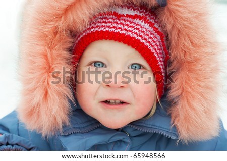 Little girl with funny face in fur hat