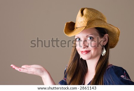 Beautiful young woman in western wear holding out hand for product placement