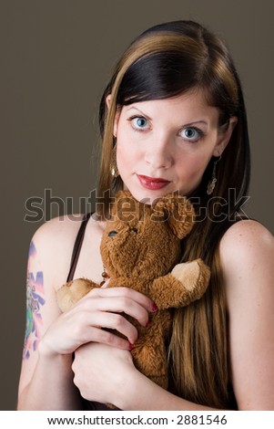 Pretty young brunette woman holding a cherished teddy bear