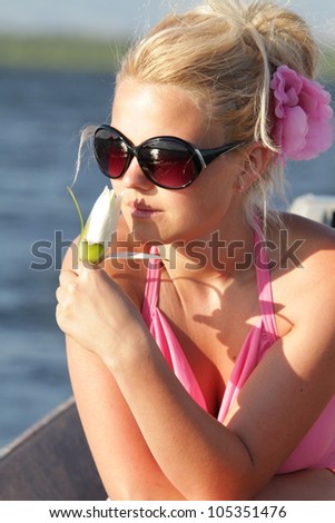 Beautiful blonde woman relaxing at the sunset in a boat.