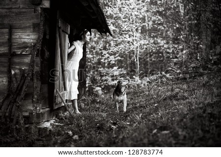 Fine art photo of a gorgeous lady with dog in a mysterious forest