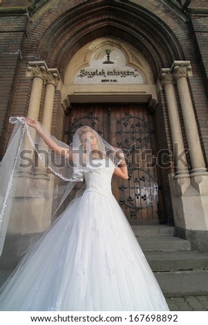 bride lightened with sun backlit, next to old church