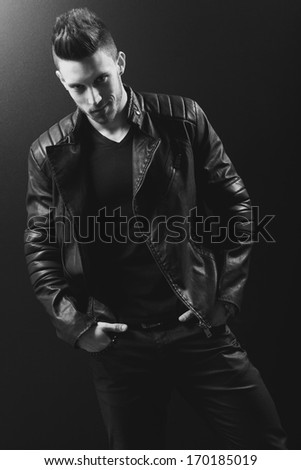 young handsome man. Studio fashion portrait. Posing over black background.B&W