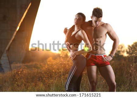 Athletic man and woman at sunset.Wide angle.