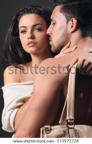 Beautiful young smiling couple in love embracing indoor.Glamour colors.No brand.