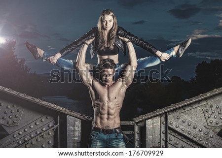Outdoor natural portrait of a gorgeous couple fitness models.Gymnastics girl.Fashion colors. Photo has an intentional film grain) .Fine art.