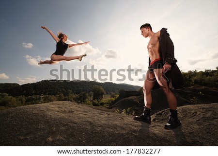 Outdoor natural portrait of a gorgeous couple fitness models.Gymnastics girl.Fashion colors.Wide angle .Fine art.