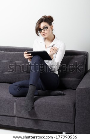 Businesswomen sitting on couch with digital tablet and studying at home