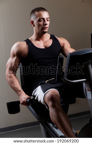 Stationary bicycles fitness man in a gym sport club .Close up.Low light.