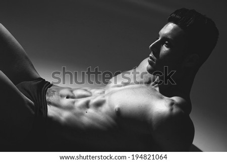 black and white studio shoot of strong athletic man on grey background