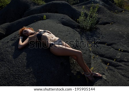 fashion portrait of sexy girl in bikini lying at desert.Fashion photo.