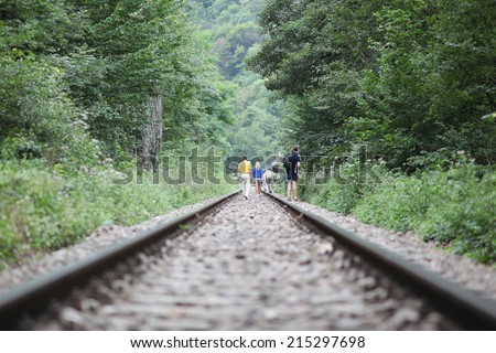 People walking down railroad track
