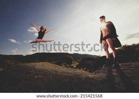 Outdoor natural portrait of a gorgeous couple fitness models.Gymnastics girl.Fashion colors.Wide angle. Photo has an intentional film grain) .Fine art.