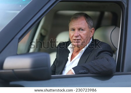 The man behind the wheel . Smiling man looking from a car window