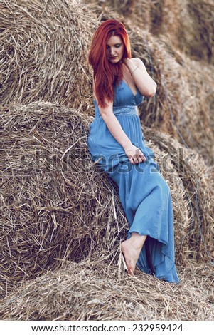Photo of sexy girl in a field with haystacks