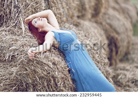 Photo of sexy girl in a field with haystacks