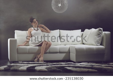 Young woman is lying on a couch .Beautiful Face of Young Woman with Clean Fresh Skin. Fashion colors.