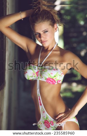 Sexy bikini model posing. Fashion outdoor photo of beautiful sensual woman with long blond hair in bikini posing on sunset