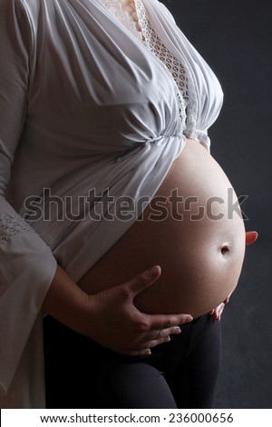 Belly of pregnant woman. Low light.