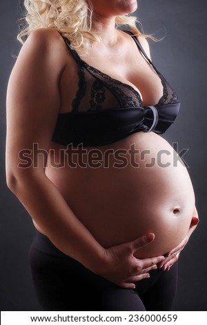 Belly of pregnant woman. Low light.